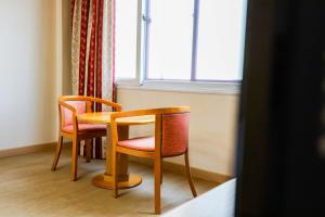 a table and chairs in a room with a window at Newvera Hotel in Cheongju