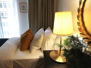 ein Schlafzimmer mit einem Bett mit Kissen und einer Lampe in der Unterkunft Stylish Downtown Toronto Residential Hotel in Toronto