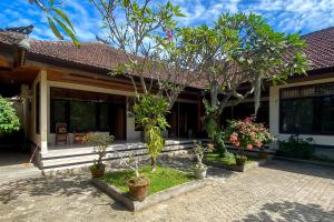 En trädgård utanför Raja Asri Guest House Sanur Mitra RedDoorz