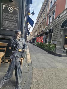 a statue of a man sitting on a bench at Leopold Chillout Hostel in Sarajevo