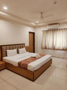 sypialnia z dużym łóżkiem i oknem w obiekcie Hotel TrushaDham Near to Mahalaxmi Temple Kolhapur w mieście Kolhapur