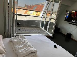 6 Zimmer Maisonette-Penthouse Pool Dachterrasse Luxus في ميونخ: غرفة نوم مع سرير ونافذة مع تلفزيون