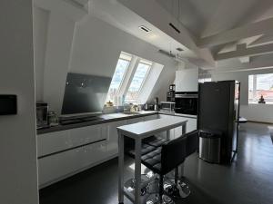 6 Zimmer Maisonette-Penthouse Pool Dachterrasse Luxus في ميونخ: مطبخ أبيض مع طاولة وثلاجة