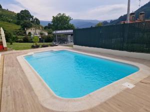 a swimming pool with blue water in a yard at Casa La Quintana in Castro-Urdiales