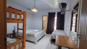 - une chambre avec 2 lits superposés, un lavabo et un miroir dans l'établissement Pousada Bougainville, à Pirenópolis