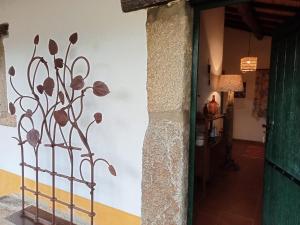 un fiore di metallo su un muro accanto a un corridoio di Quinta dos Trevos - Artes e Ofícios a Ladoeiro