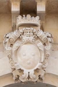 uma escultura de pedra de um rosto no lado de um edifício em Palazzo Zimara Boutique Hotel em Lecce