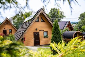 a wooden house with a gambrel roof at Domki Całoroczne Osada Zbójecka Jandura in Kluszkowce