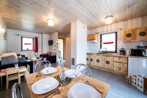 a kitchen and living room with a wooden ceiling at Domki Całoroczne Osada Zbójecka Jandura in Kluszkowce