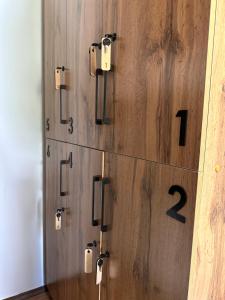 a wooden clock with numbers on a wooden wall at Hostel Saruu in Bishkek