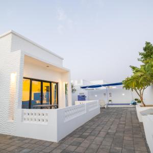 ein weißes Haus mit einer Terrasse und einem Hof in der Unterkunft THE POOL VILLA - TANUF in Nizwa