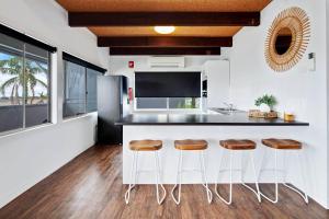 a kitchen with a counter with stools and a sink at Harbour Marina - Absolute waterfront apartment in Batemans Bay