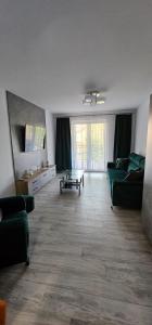 uma sala de estar com um sofá verde e uma mesa em Apartament Gabi em Giżycko