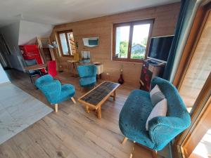 sala de estar con sillas azules y mesa en Maison d'hôtes des Bassins d'Oche, en Saint-Paul-en-Chablais