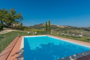 una piscina con acqua blu in un cortile di The Grapevine by MANVI a Montepulciano