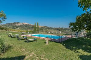 una piscina con panchine in erba accanto ad essa di The Grapevine by MANVI a Montepulciano