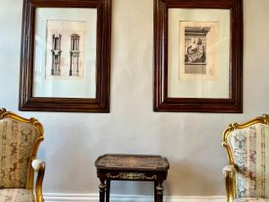 duas cadeiras e um banco num quarto com duas fotografias em Thirty8 Heritage House em Chania