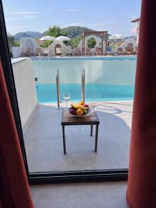 een tafel met een fruitschaal naast een zwembad bij Hayat Apart Hotel in Oludeniz