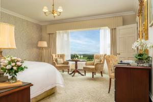 una camera con letto, tavolo e sedie di Glenlo Abbey Hotel a Galway