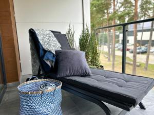 een zwarte bank op een veranda met een mand bij Apartament Augustów in Augustów