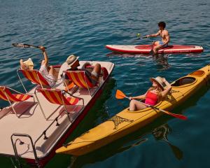 a group of people on boats in the water at HERMITAGE Lake Lucerne - Beach Club & Lifestyle Hotel in Luzern