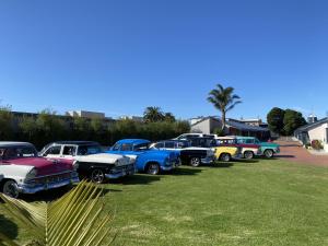 eine Reihe alter Autos, die auf einem Feld geparkt sind in der Unterkunft Lakeside Motel Waterfront in Lakes Entrance