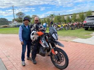 Ein Mann und ein Mann stehen neben einem Motorrad in der Unterkunft Lakeside Motel Waterfront in Lakes Entrance