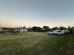 eine Gruppe von drei Autos, die auf einem Feld geparkt sind in der Unterkunft Lakeside Motel Waterfront in Lakes Entrance