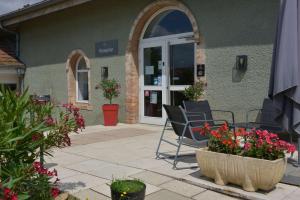 eine Terrasse mit Stühlen und Blumen vor einem Gebäude in der Unterkunft Best Western Golf d'Albon in Albon