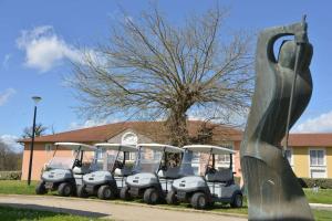 eine Gruppe von Golfwagen, die vor einem Haus geparkt sind in der Unterkunft Best Western Golf d'Albon in Albon