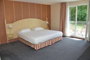 ein Schlafzimmer mit einem großen Bett und einem Balkon in der Unterkunft Best Western Golf d'Albon in Albon