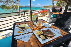 uma mesa com dois pratos de comida e o oceano em Camping Park Soline em Biograd na Moru