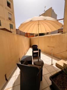 um pátio com uma mesa e um guarda-chuva em Simo and Manu's little home em Cagliari