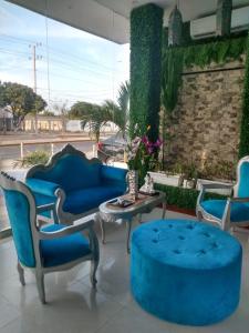 een woonkamer met blauwe stoelen en een tafel bij Mar Inn Hotel in Ríohacha