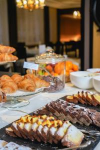 un tavolo con pane, prodotti da forno e altri prodotti alimentari di Hotel Touring Dolomites a Santa Cristina in Val Gardena