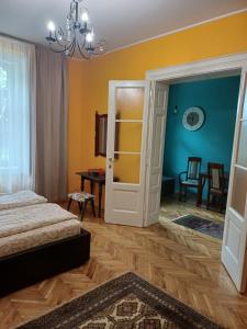 Sombor 19 Central Apartment في سومبور: غرفة نوم بسرير وباب مفتوح