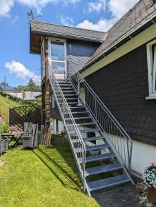 Ein Mann steht auf der Treppe eines Hauses in der Unterkunft Ferienwohnung Soreth in Schmallenberg