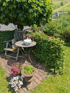 einen Tisch und eine Bank in einem Garten mit Blumen in der Unterkunft Ferienwohnung Soreth in Schmallenberg