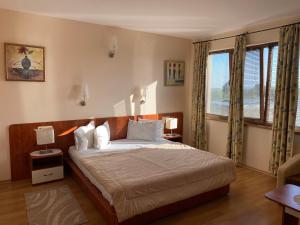 a bedroom with a bed and a large window at Guest House Golden Flake 4km from Bolata beach in Bŭlgarevo