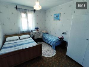 a bedroom with two beds and a table and a window at Гостевой дом золотые пески in Zatoka