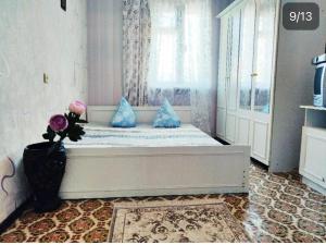 a bedroom with a bed with blue pillows and a window at Гостевой дом золотые пески in Zatoka