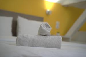 - un distributeur de serviettes sur un lit dans une chambre d'hôtel dans l'établissement Vila Storia, à Niš