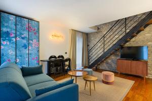 a living room with a blue couch and a tv at Hotel Ancora in Verbania