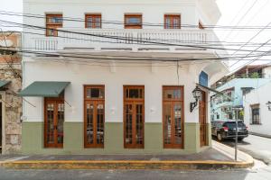 um edifício branco com portas de madeira numa rua em Empyrean Art Deco em Santo Domingo