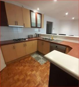 a kitchen with wooden cabinets and a wooden floor at A Unique Holiday Home between Avalon Airport and Melbourne CBD in Werribee