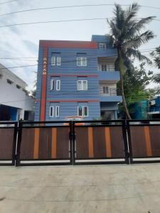 a blue building with a palm tree in front of it at Rajam in Chennai