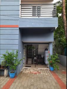 a blue building with a dog in a cage at Rajam in Chennai