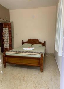 a bed with a wooden frame in a room at Rajam in Chennai