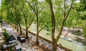 a street with cars parked next to a river at Riverside Apartment No1 in Esztergom