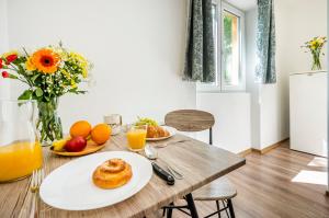 a table with a plate of food and orange juice at Riverside Apartment No1 in Esztergom